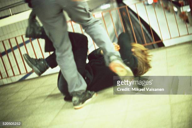 man kicking a woman in subway station - fight man stock-fotos und bilder