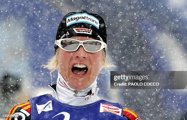 Germany's Claudia Kuenzel celebrates on the finish line after winning a Women's World Cup 6 x 1,1km team sprint cross country race and giving the...