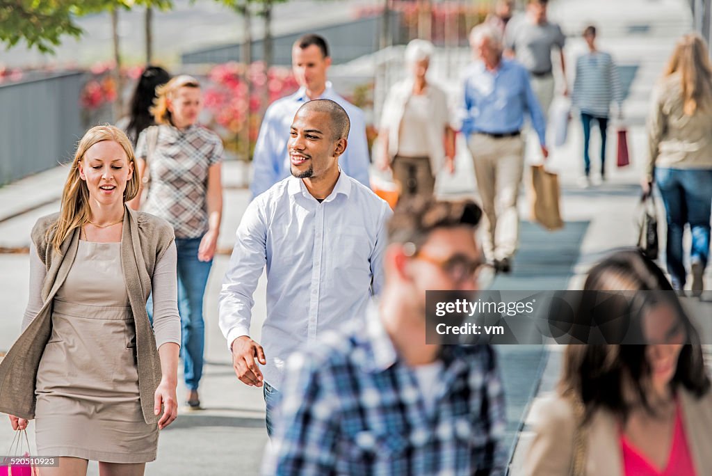 Couple on crowded city street after shopping