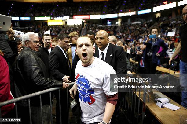 Supporter of Democratic presidential candidate Bernie Sanders shouts slogans against Republican presidential candidate Donald Trump while he speaks...