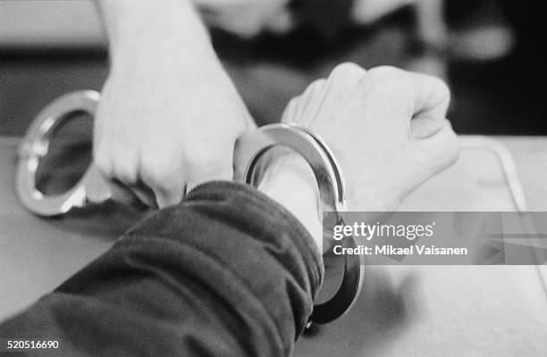 man is being handcuffed - manette foto e immagini stock