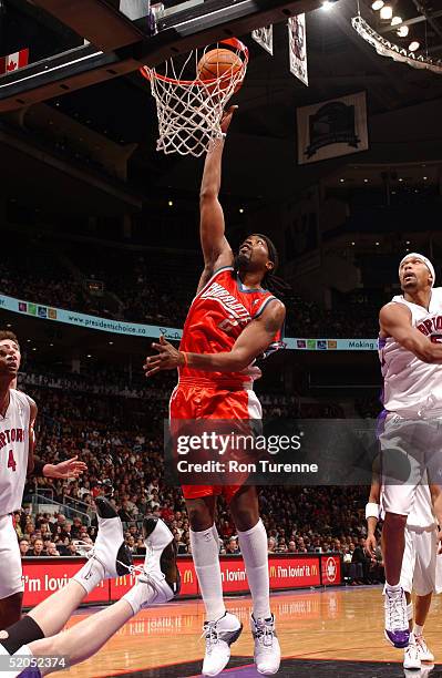 Melvin Ely of the Charlotte Bobcats shoots against Jalen Rose and Chris Bosh of the Toronto Raptors on January 23, 2005 at the Air Canada Centre in...