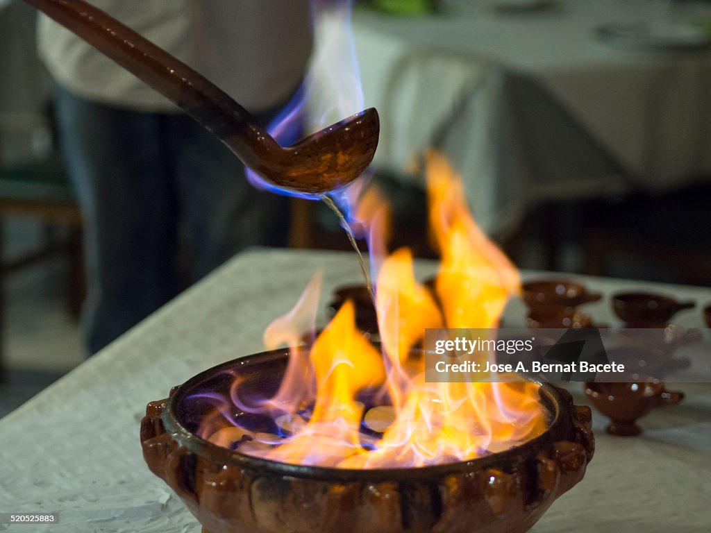 Preparing a queimada with a casserole of mud