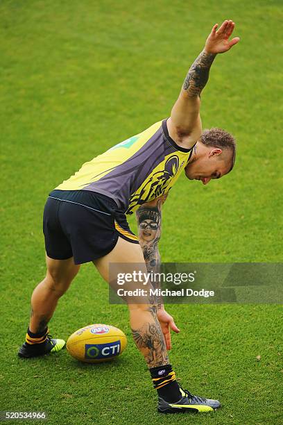 Dustin Martin of the Tigers stretches during a Richmond Tigers AFL media session at ME Bank Centre on April 12, 2016 in Melbourne, Australia.