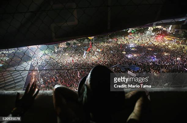 People watch former President Luiz Inacio Lula da Silva , 'Lula', speak at a rally supporting President Dilma Rousseff in the historic Lapa...