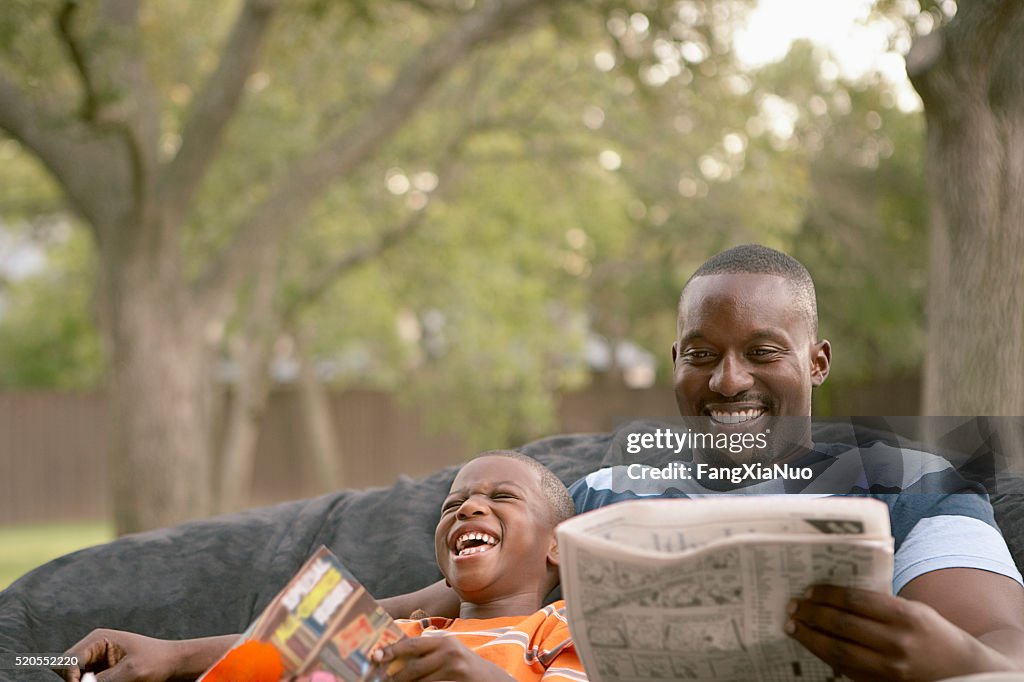 Father and son laughing and reading