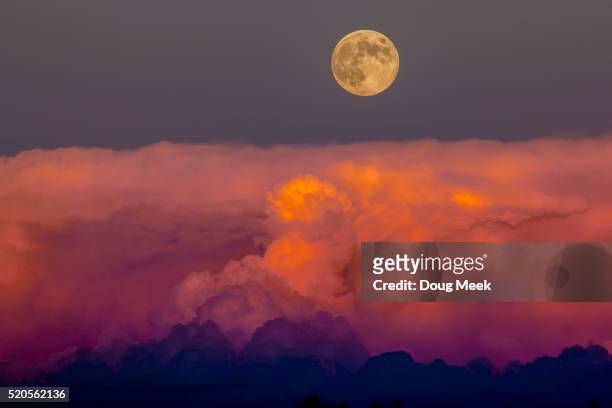 harvest moon rising above storm clouds, western colorado. - full moon stock pictures, royalty-free photos & images