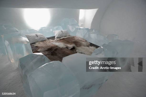 reindeer skin covered bed at icehotel - ice hotel sweden stock-fotos und bilder