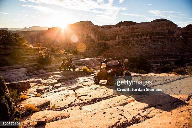 off road vehicles driving a rock path in moab. - moab utah fotografías e imágenes de stock