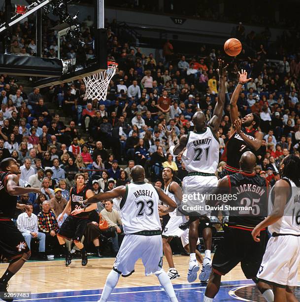 John Salmons of the Philadelphia 76ers shoots over Kevin Garnett of the Minnesota Timberwolves during a game at Target Center on January 7, 2005 in...