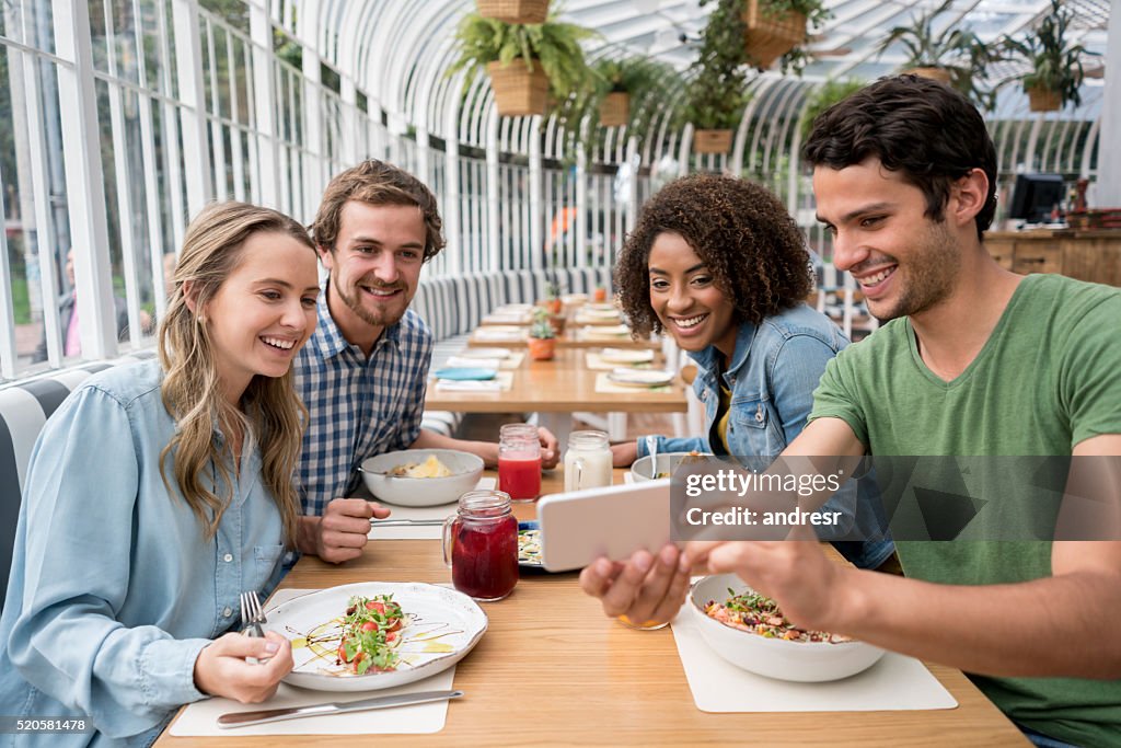 Amici prendendo un selfie in un ristorante