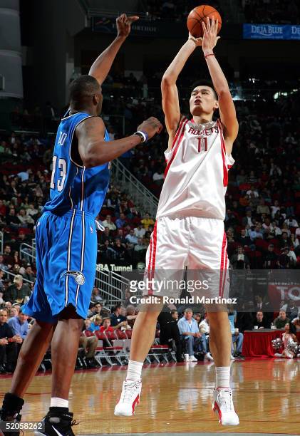 Yao Ming of the Houston Rockets takes a shot against Kelvin Cato of the Orlando Magic on January 24, 2005 at the Toyota Center in Houston, Texas. The...