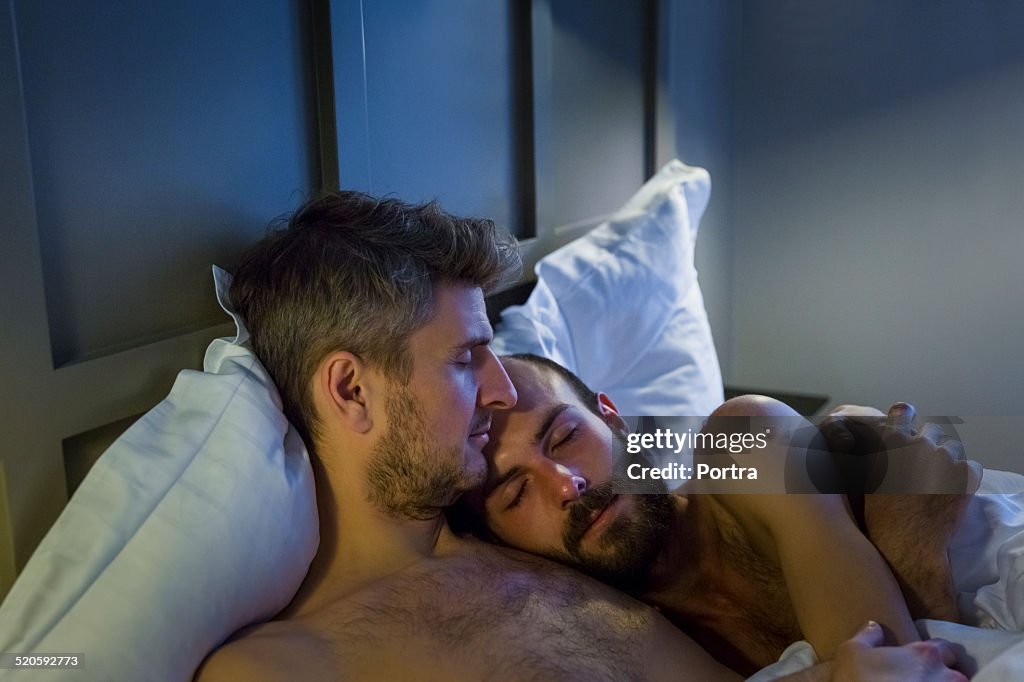 Gay couple sleeping in bed