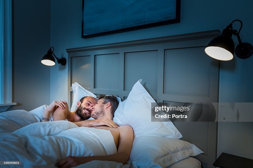 Gay couple lying in bed