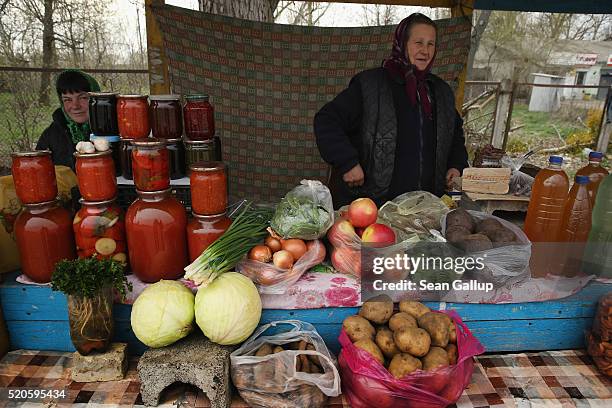 Vendor sells locally-produced vegetables, birch bark juice, jam and other preserves on April 9, 2016 in Demydiv, Ukraine. Demydiv lies south of the...