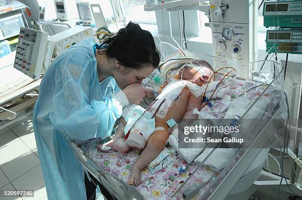 Snyezhana Tertishneya kisses the hand of her son Ruslan, aged three months, following his operation to correct severe birth defects in his heart at...