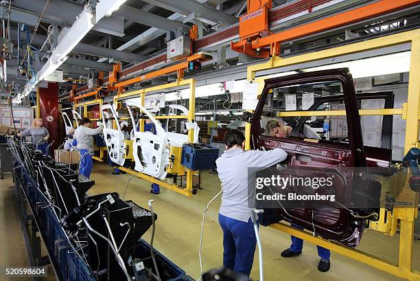 Workers attach fittings to doors for Lada automobiles on the production line at the headquarters of AvtoVAZ OAO in Togliatti, Russia, on Monday,...