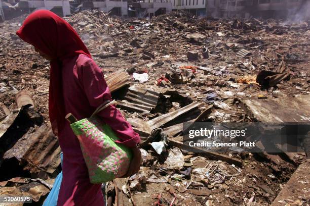 Woman walks through an area totally that has been totally demolished January 25, 2005 in the tsunami-ravaged town of Meulaboh, Indonesia. Nearly a...