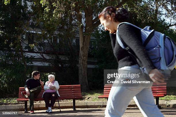 Sebastian Schirrmeister a 20-year-old German volunteer from Berlin, sits on a park bench with elderly Jewish Holocaust survivor Yanina Brunitzky near...