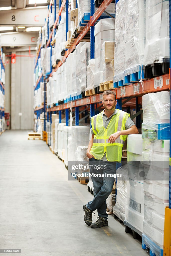 Worker standing by shelves in warehouse