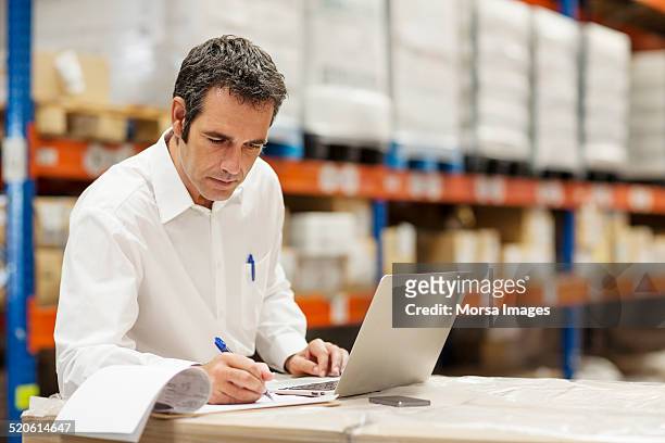 supervisor working in warehouse - distribution warehouse stockfoto's en -beelden