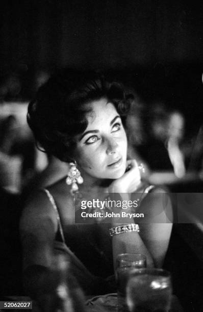 British-born actoress Elizabeth Taylor watches her fiance Eddie Fisher as he performs on stage at the Tropicana in Las Vegas, Nevada, August 1959....