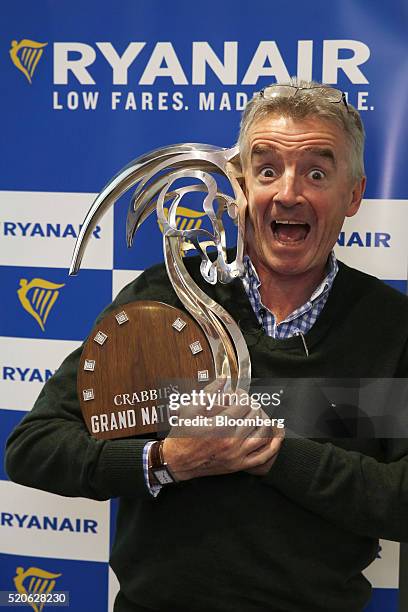 Michael O'Leary, chief executive officer of Ryanair Holdings Plc, poses with his Grand National 2016 winners trophy following a news conference at...
