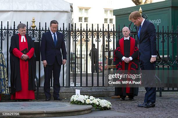 Britain's Prince Harry , watched by British Prime Minister David Cameron , lays a wreath at the Innocent Victims Memorial prior to a service of...