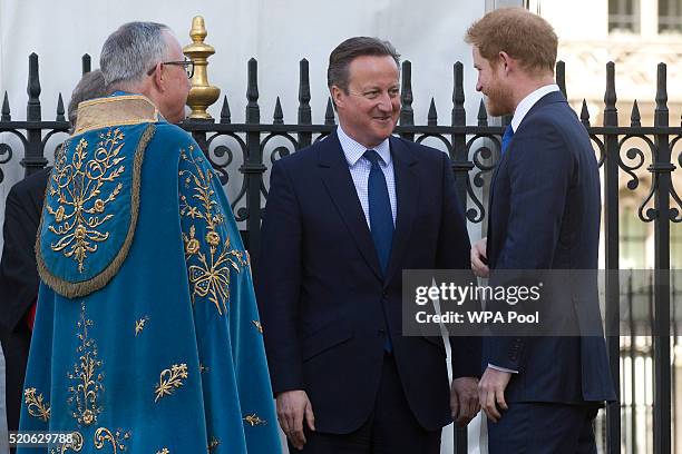 British Prime Minister David Cameron speaks with Britain's Prince Harry before Prince Harry lays a wreath at the Innocent Victims Memorial prior to a...