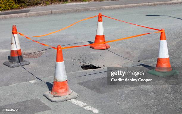 sinkhole opening up in the road in ambleside - verkehrswarnung stock-fotos und bilder