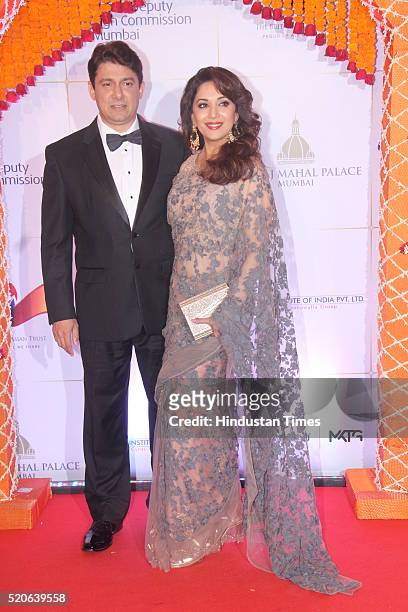 Bollywood actress Madhuri Dixit with her husband Shriram Nene poses for the cameras as they arrive for the Bollywood theme dinner at the Taj Palace...