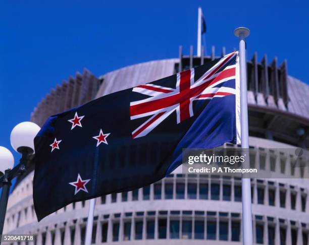 new zealand flag and the beehive - wellington nieuw zeeland stockfoto's en -beelden