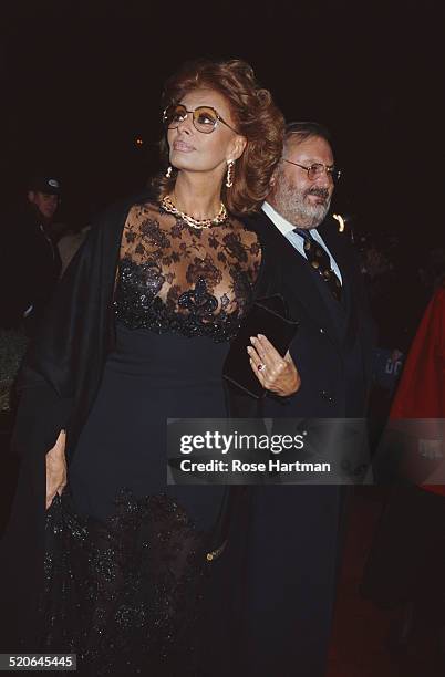 Italian fashion designer Gianfranco Ferré and Italian actress Sophia Loren attend the premiere for Robert Altman's 'Ready to Wear' , 1994.