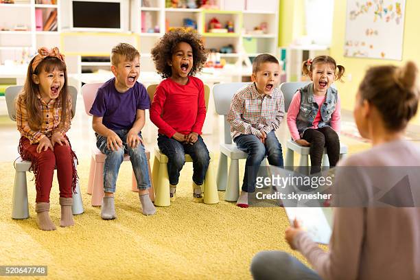 group of children screaming during storytelling in kindergarten. - teacher shouting stock pictures, royalty-free photos & images
