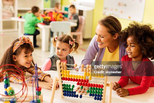 little girls and teacher learning at preschool. - nursery school building stock pictures, royalty-free photos & images