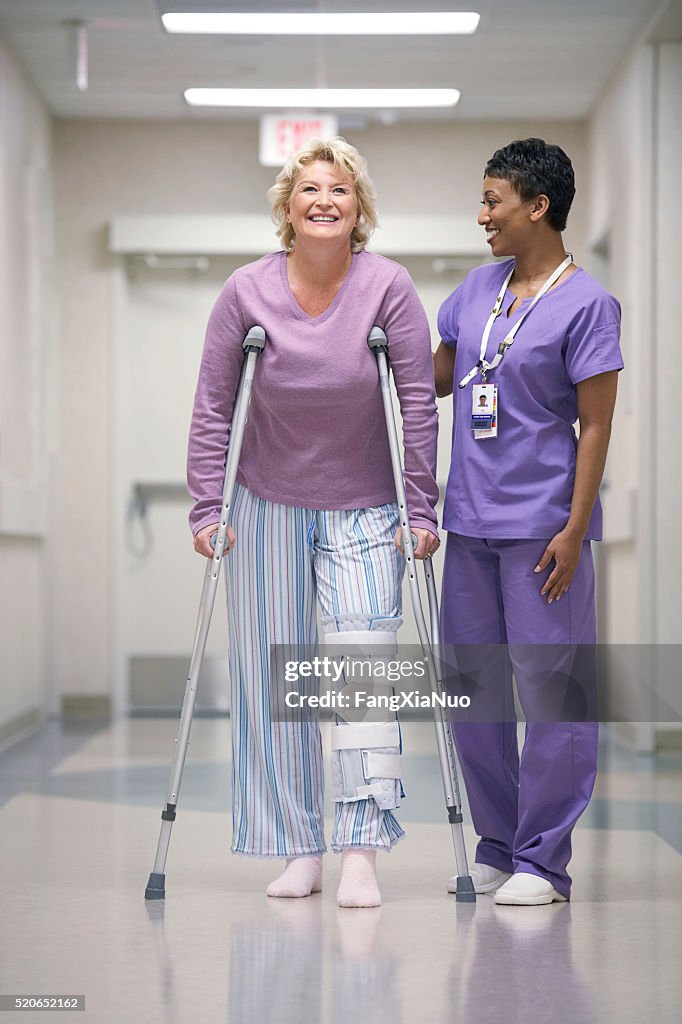 Nurse helping patient with crutches