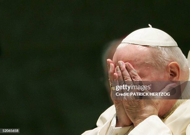 Pope John Paul II holds his face as he presides over his weekly general audience at the Vatican, 26 January 2005. The Nazi death camps represent one...