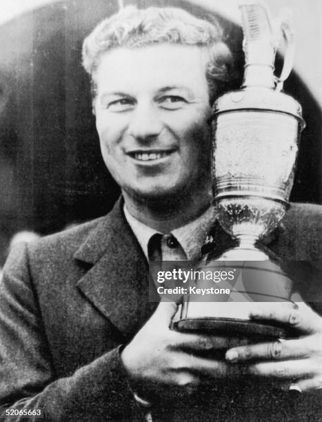 Australian golfer Peter Thomson with his trophy after winning the Open Championship at Hoylake for the third year in succession, 7th July 1956. He is...