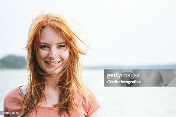 retrato de una joven mujer riendo cabeza roja sobre fondo de naturaleza - redhead teen fotografías e imágenes de stock