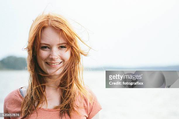 portrait laughing young redhead woman on nature background - lang haar stockfoto's en -beelden