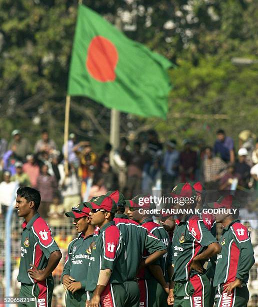 Bangladeshi cricketers are framed by the countries flag as they await the third umpires decisionduring the third One day International between...