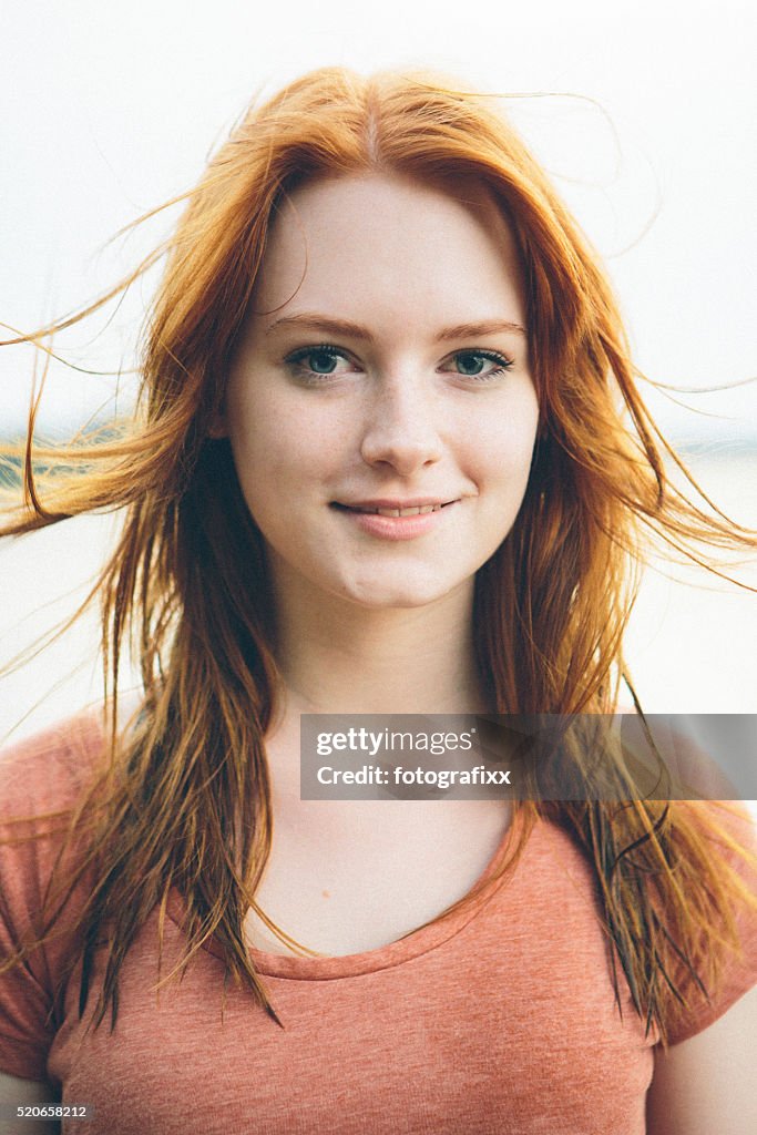 Portrait smiling young redhead woman on nature background