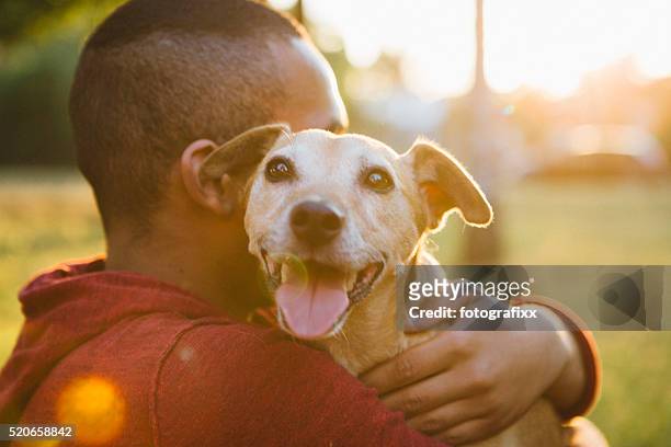 vue arrière d'un jeune homme câlin son petit chien - boy dog photos et images de collection