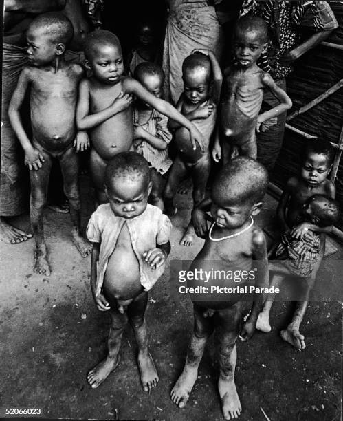 Cluster of naked, starving children with distended bellies during the Biafra War, Nigeria, late 1960s.