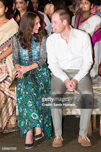 Prince William, Duke of Cambridge and Catherine, Duchess of Cambridge watch dancers by the fireside during a Bihu Festival Celebration at Diphlu...