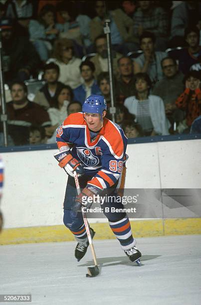Canadian professional ice hockey player Wayne Gretzky forward of the Edmonton Oilers skates on the ice during a road game, mid 1980s.