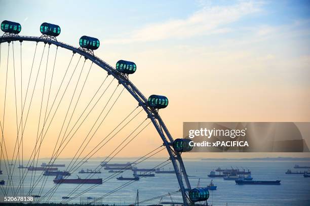 shipping boats and freighters at sunset off the coast of singapore as seen through the singapore fly - singapore flyer - fotografias e filmes do acervo