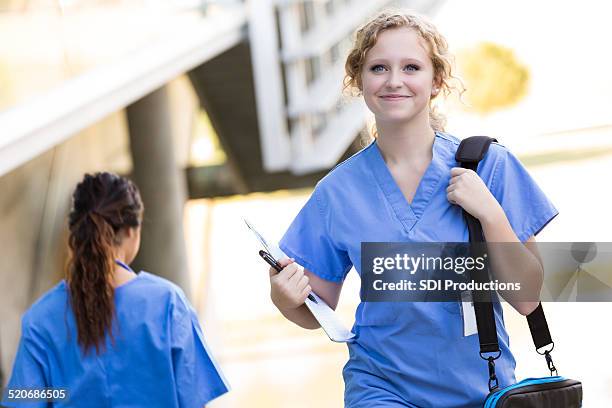 nursing or medical student walking to class on hospital campus - schooldokter stockfoto's en -beelden