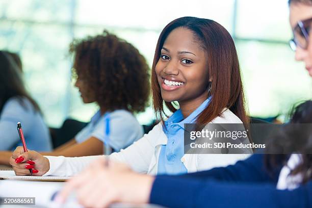pretty african american private school student smiling during class - african american school uniform stock pictures, royalty-free photos & images
