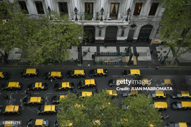 Cabs are seen along Mayo avenue as taxi drivers protest against Uber in Buenos Aires on April 12, 2016. Uber started operating in Buenos Aires...